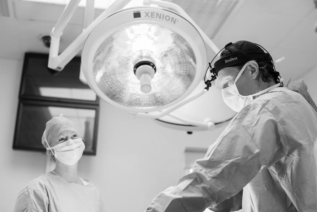 To kirurger i operationsstue under xenon-lampe