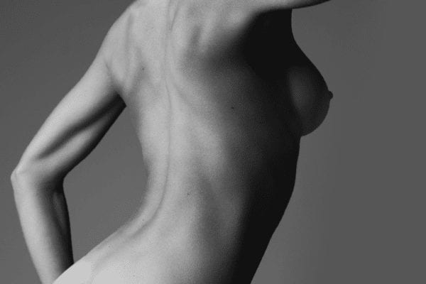 Sort-hvid fotografi af kvindelig torso set fra siden