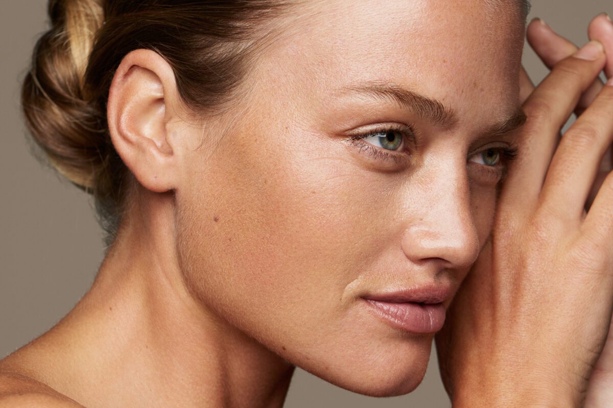 Kvinde med ren hud og naturlig makeup ser fremad