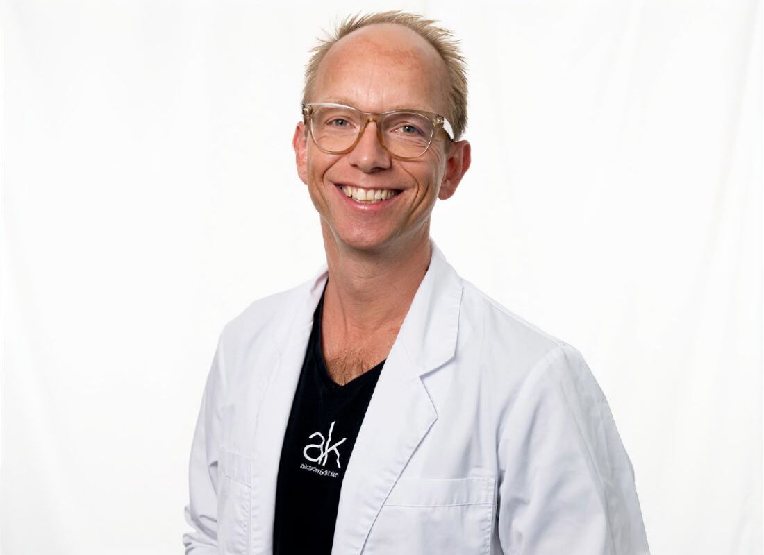 Personalebillede af Anders Ulrik iført hvid lægejakke og briller
