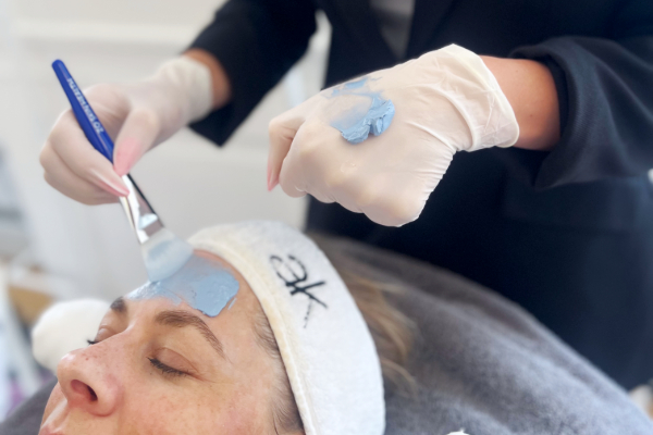 Påføring af ZO Stimulation Peel med pensel på kvindes pande