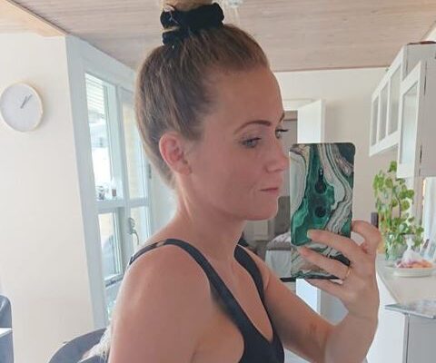 Louise tager spejlselfie i sort top med hår i høj knold